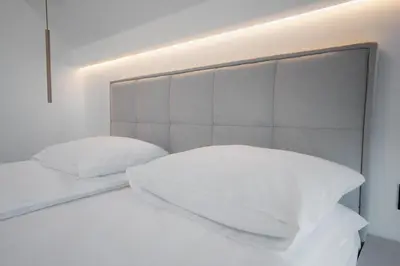 a white bed with two pillows on top of it at Zamkowy Zakątek - Luksusowe domki z jacuzzi in Nowy Wiśnicz