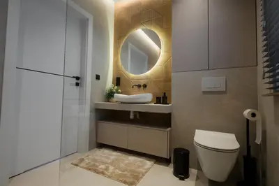 a bathroom with a sink and a toilet and a mirror at Zamkowy Zakątek - Luksusowe domki z jacuzzi in Nowy Wiśnicz