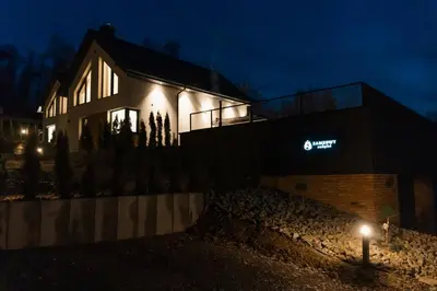 a building with a sign on the side of it at night at Zamkowy Zakątek - Luksusowe domki z jacuzzi in Nowy Wiśnicz
