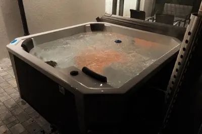 a bath tub filled with water in a bathroom at Zamkowy Zakątek - Luksusowe domki z jacuzzi in Nowy Wiśnicz