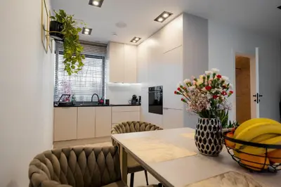 a kitchen with a table with a vase of flowers at Zamkowy Zakątek - Luksusowe domki z jacuzzi in Nowy Wiśnicz
