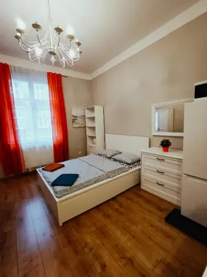 a bedroom with a bed and a chandelier at Daniel Apart Hotel Krakow Central in Kraków