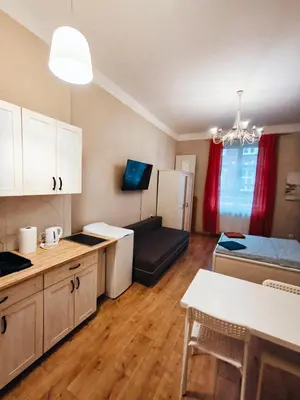 a kitchen and living room with a table and a couch at Daniel Apart Hotel Krakow Central in Kraków