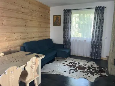 a living room with a blue couch and a table at Domki przy szlaku Szczebel in Lubień