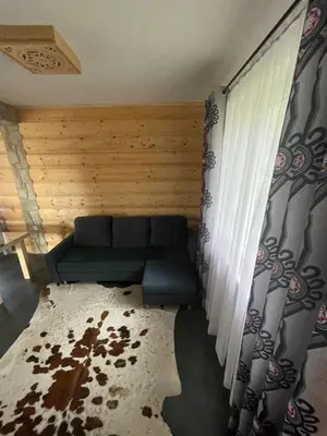 a living room with a couch and a window at Domki przy szlaku Szczebel in Lubień