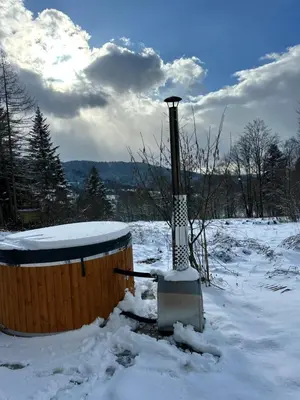 a wooden barrel in the snow with a pole at Domki przy szlaku Szczebel in Lubień