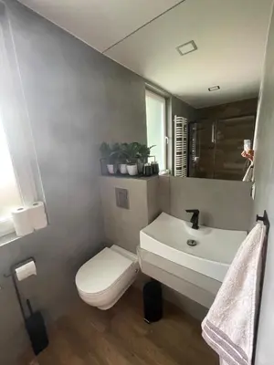 a bathroom with a white toilet and a sink at Domki przy szlaku Szczebel in Lubień