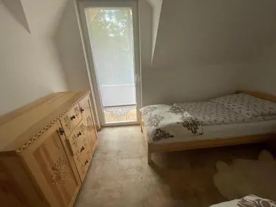 a bedroom with a bed and a dresser and a window at Domki przy szlaku Szczebel in Lubień