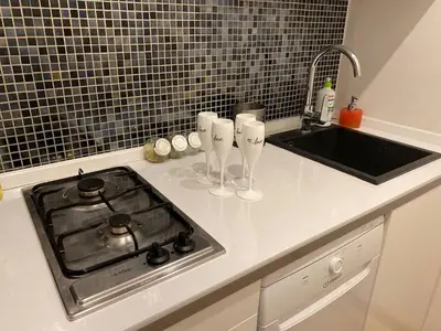 a kitchen counter with a stove and a sink at Gold ROOM in Kraków