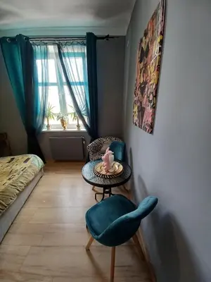 a room with a chair and a table and a bed at Gold ROOM in Kraków