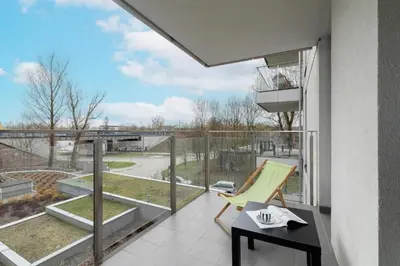 a balcony with a chair and a table and a view at Spacious Studio Zabłocie with Balcony Krakow in Kraków