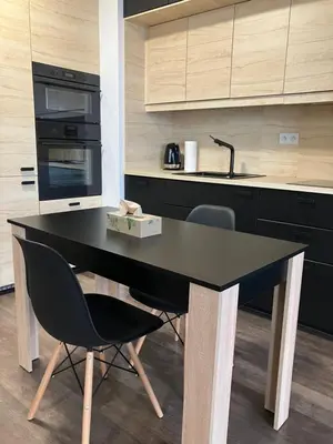 a black table in a kitchen with two chairs at Spacious Studio Zabłocie with Balcony Krakow in Kraków