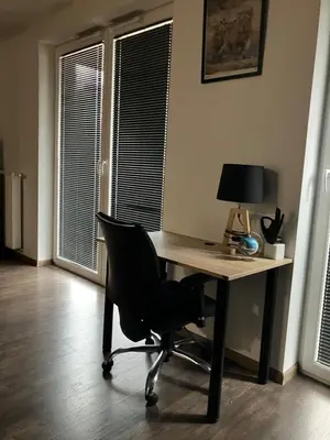 a desk with a chair and a lamp in a room at Spacious Studio Zabłocie with Balcony Krakow in Kraków