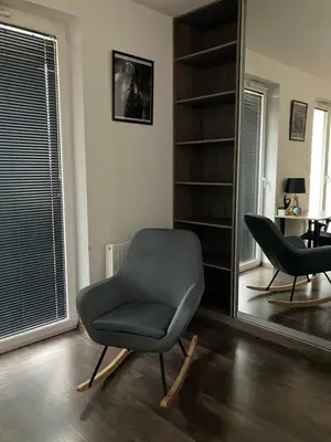a living room with a chair and a mirror at Spacious Studio Zabłocie with Balcony Krakow in Kraków