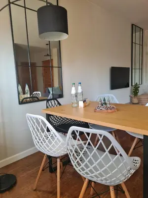 a dining room table with white chairs and a mirror at Home4You in Kraków