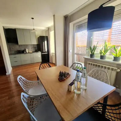 a dining room table with chairs and a kitchen at Home4You in Kraków