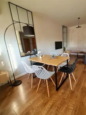 a dining room with a table and chairs and a mirror at Home4You in Kraków