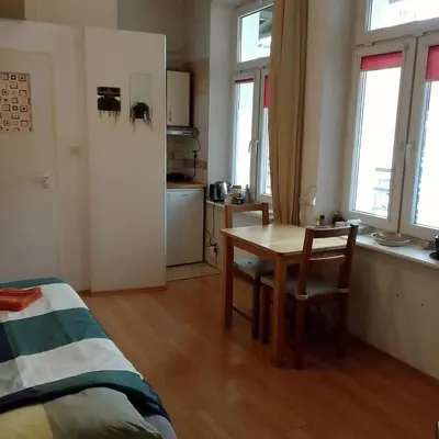 a room with a table and a kitchen with windows at Best location Private apartment in Kraków