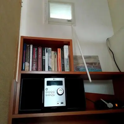 a book shelf with a radio and books on it at Best location Private apartment in Kraków