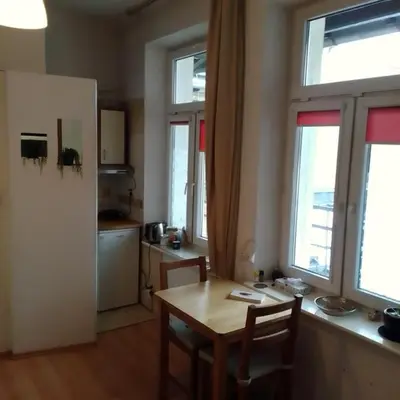 a kitchen with a table and chairs and windows at Best location Private apartment in Kraków