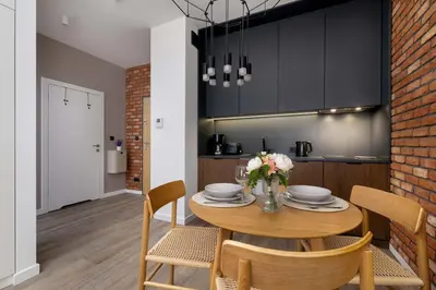 a kitchen and dining room with a table and chairs at Rakowicka Brick Apartment near Station by Noclegi Renters in Kraków