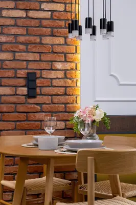 a dining room table with a brick wall at Rakowicka Brick Apartment near Station by Noclegi Renters in Kraków