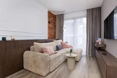 a living room with a couch and a table at Rakowicka Brick Apartment near Station by Noclegi Renters in Kraków