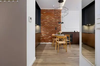 a kitchen and dining room with a brick wall at Rakowicka Brick Apartment near Station by Noclegi Renters in Kraków