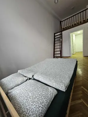 a large bed in a room with a ladder at Top Apartment in Kraków