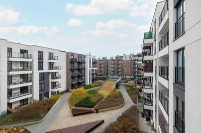 an apartment complex with a garden between two buildings at Stylish Apartment with Balcony near Krakow Old Town by Noclegi Renters in Kraków