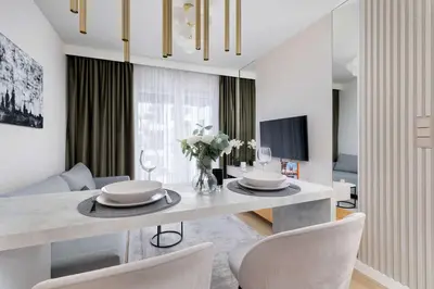 a living room with a dining room table with chairs at Stylish Apartment with Balcony near Krakow Old Town by Noclegi Renters in Kraków