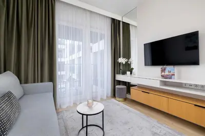 a living room with a couch and a tv at Stylish Apartment with Balcony near Krakow Old Town by Noclegi Renters in Kraków