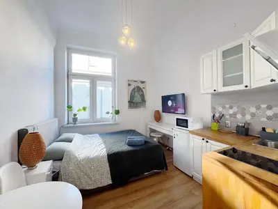a bedroom with a bed and a kitchen with a sink at Pstrak zyblikiewicza in Kraków