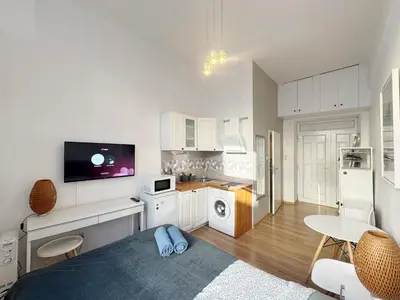 a large white kitchen with white cabinets and a table at Pstrak zyblikiewicza in Kraków