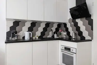 a kitchen with a black and white checkered wall at Charming One Bedroom Apartment in Krakow with a Perfect Location by Noclegi Renters in Kraków