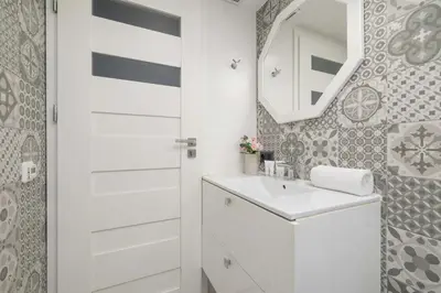 a white bathroom with a sink and a mirror at Charming One Bedroom Apartment in Krakow with a Perfect Location by Noclegi Renters in Kraków