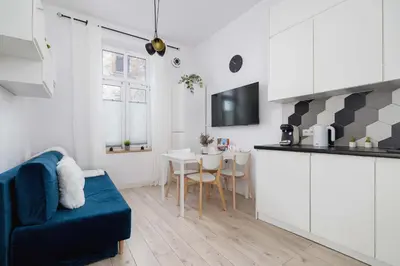 a kitchen and living room with a couch and a table at Charming One Bedroom Apartment in Krakow with a Perfect Location by Noclegi Renters in Kraków
