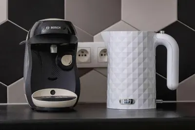 a black and white coffee maker next to a cup at Charming One Bedroom Apartment in Krakow with a Perfect Location by Noclegi Renters in Kraków