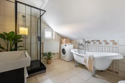 a bathroom with a tub and a washing machine at ANTA Salt Mine in Wieliczka