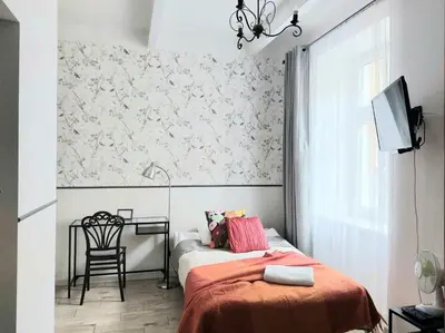 a bedroom with a bed and a table with a chair at Apartament Różana przy ICE in Kraków