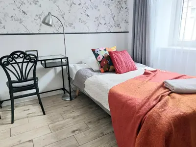 a bedroom with a bed and a chair and a table at Apartament Różana przy ICE in Kraków