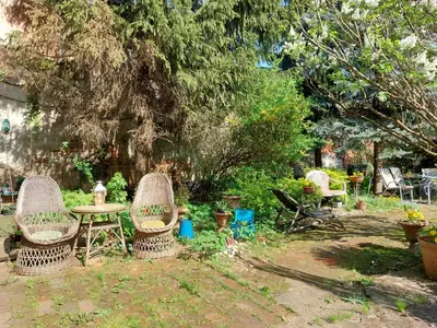 a garden with two chairs and a table and some plants at Apartament Różana przy ICE in Kraków