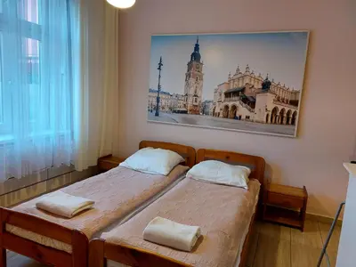 two beds in a room with a picture on the wall at Apartament Różana przy ICE in Kraków