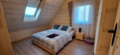 a bedroom with a bed in a log cabin at Chata Przysłop in Stryszawa