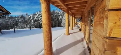 a porch of a wooden cabin in the snow at Chata Przysłop in Stryszawa