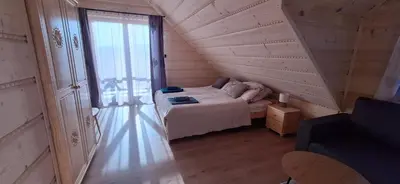 a bedroom with a bed and a large window at Chata Przysłop in Stryszawa