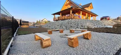 a building with wooden benches on a pile of rocks at Chata Przysłop in Stryszawa
