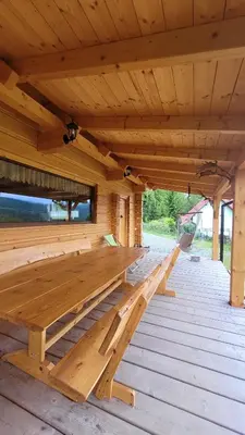 a wooden bench on a wooden deck at Piernikowa Chata in Zawoja