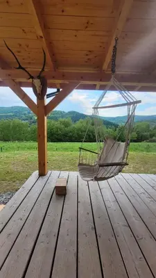 a hammock hanging from a roof on a wooden deck at Piernikowa Chata in Zawoja