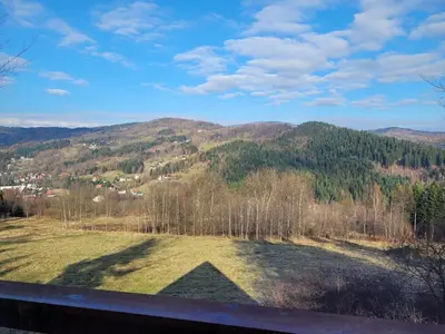 a view of a field with mountains in the background at Piernikowa Chata in Zawoja